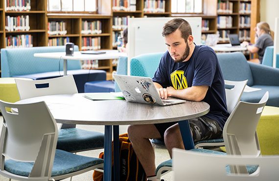 Young TWU male student on his laptop